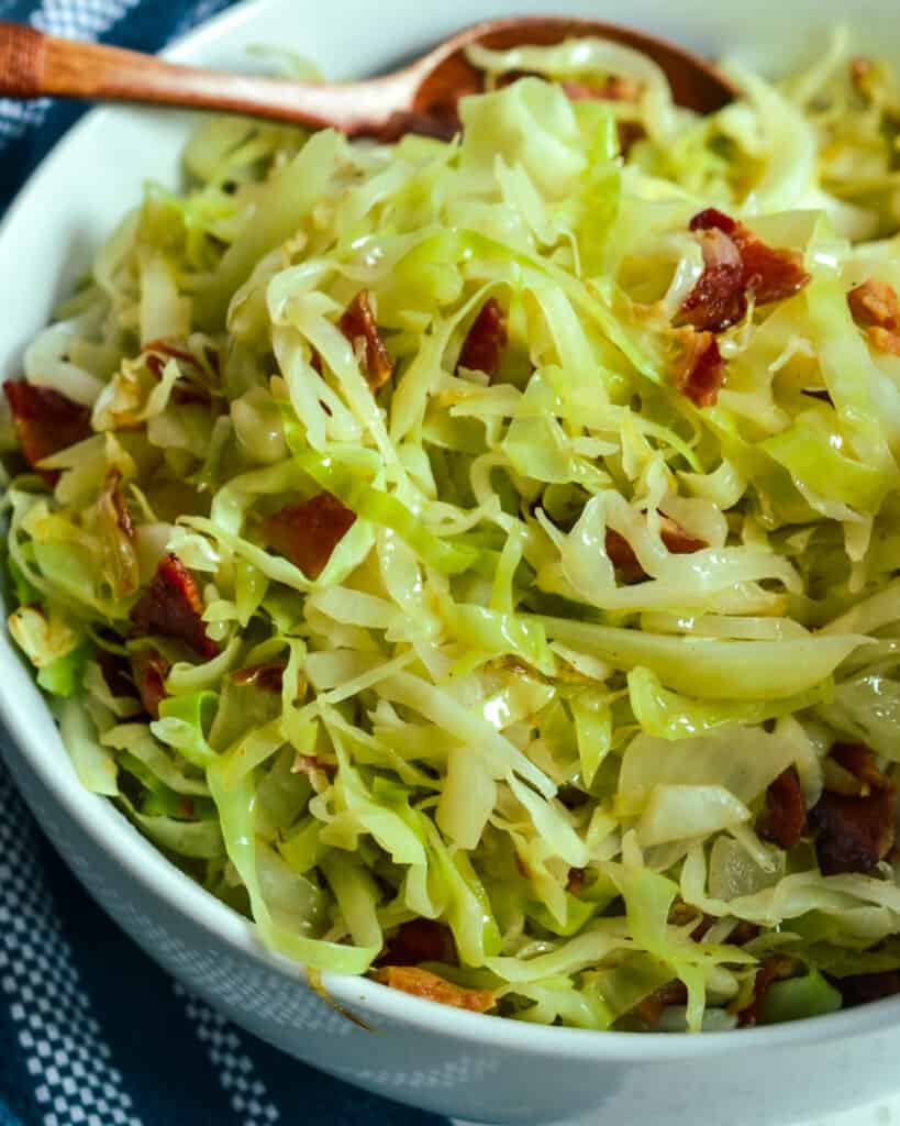 A close up view of fried cabbage with bacon and onions. 