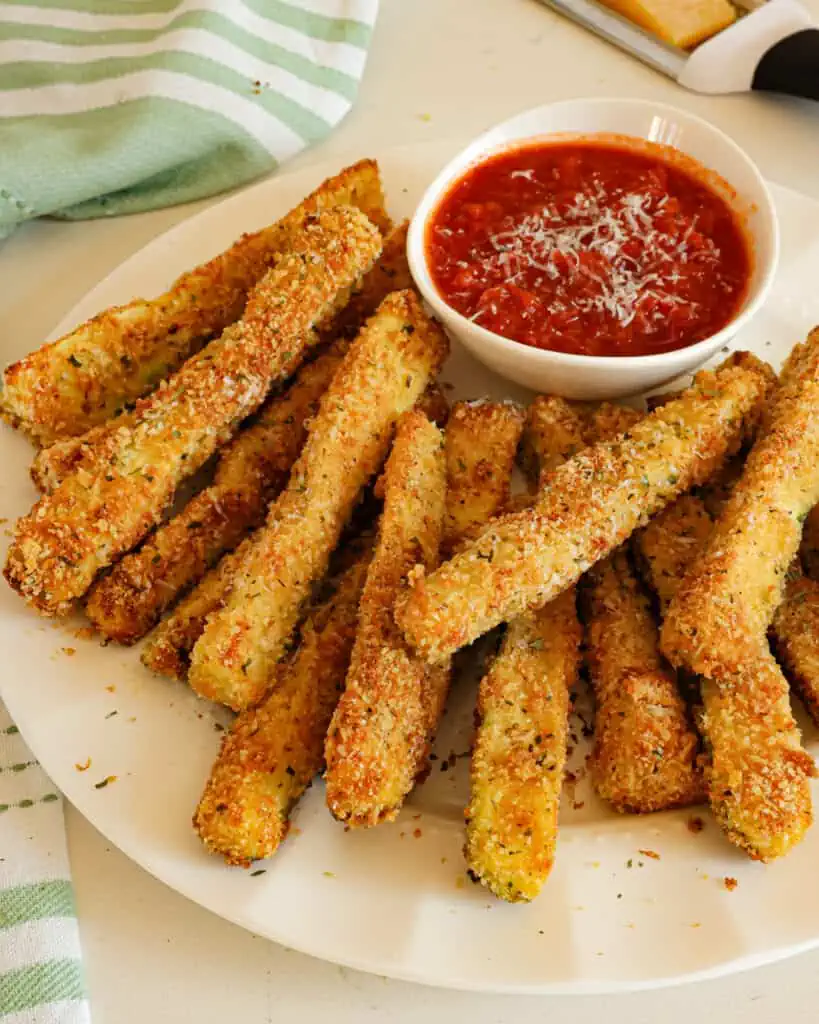 Your family and friends will love this fun and easy breaded zucchini recipe.  Its crispy coating is seasoned with Parmesan, garlic, and oregano for the best flavor. 