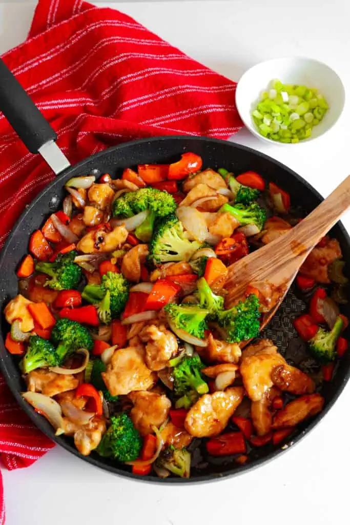 Hunan chicken is a classic Chinese stir-fry with thinly sliced chicken breasts, celery, broccoli, red bell pepper, and carrots in a savory garlic ginger sauce. 