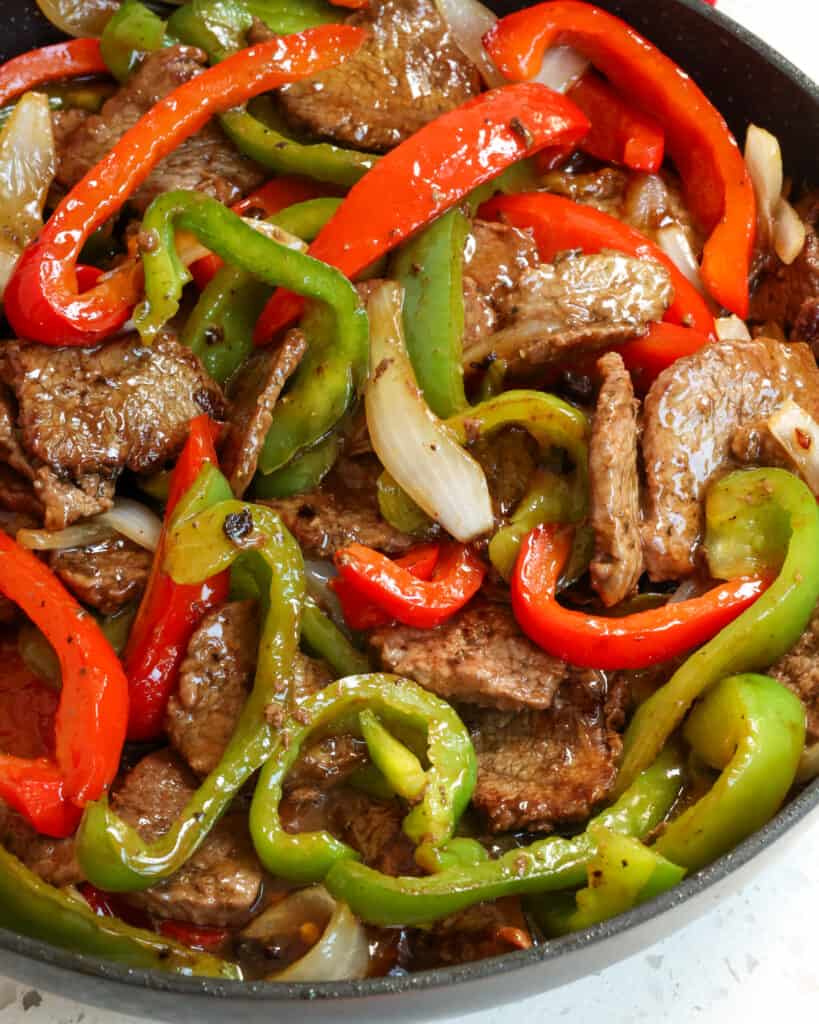 One Skillet Pepper Steak is a super flavor packed stir fry meal full of tender steak, crisp bell peppers, and sweet onions all in a sweet and savory ginger sauce. 