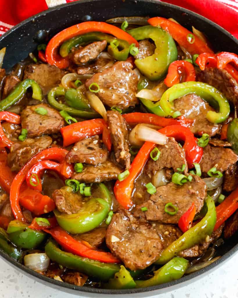 A favorite one skillet pepper steak with stir fried crisp tender steak, green and red bell peppers, and sweet yellow onion in a sweet and savory beef ginger sauce. 