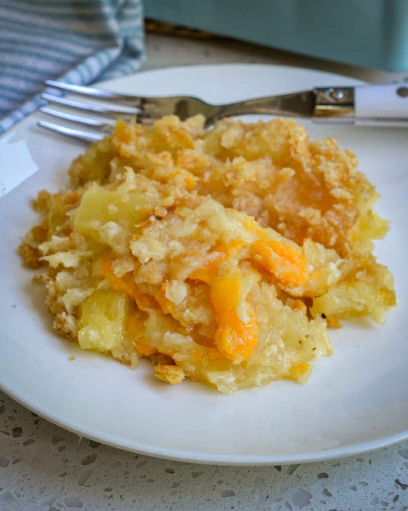 Pineapple casserole on a single serving plate with a fork. 