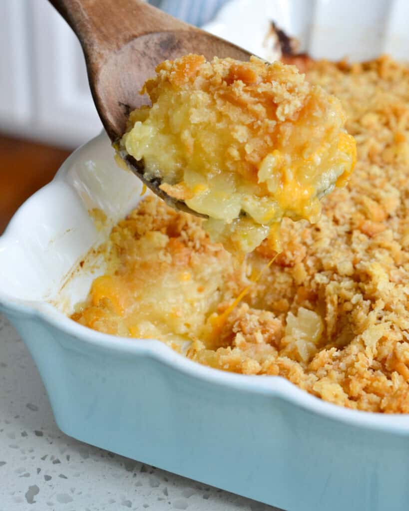 Pineapple Casserole on a spoon above the casserole.