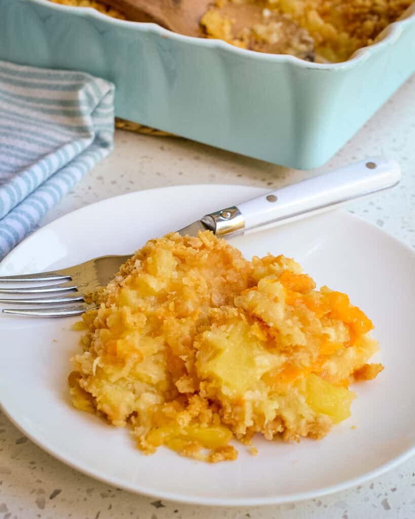 Pineapple Casserole on a white plate with a fork.