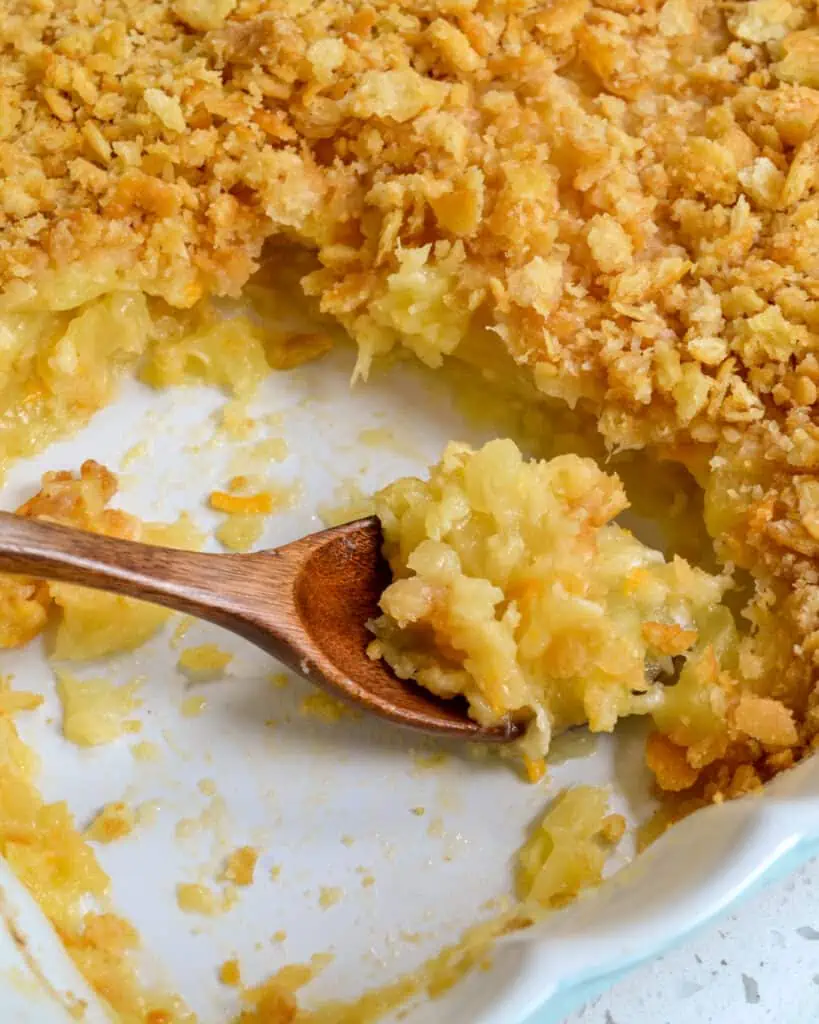 This traditional southern Pineapple Casserole recipe brings canned pineapple, flour, cheddar cheese, butter, and crushed crackers together in a mouthwatering dish that can serve as a side or a dessert