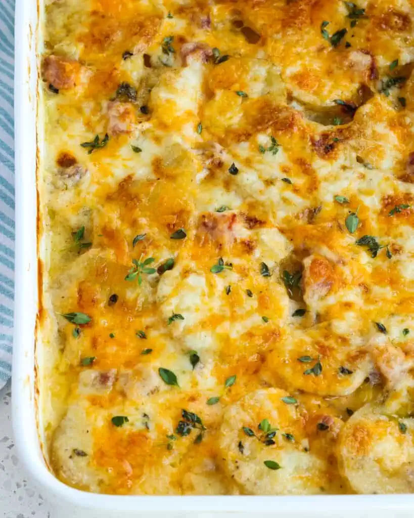 Scalloped Potatoes and Ham are sliced Yukon gold potatoes and smoked ham in a delicious creamy, lightly seasoned white sauce, all topped with sharp cheddar and Monterey Jack Cheese.