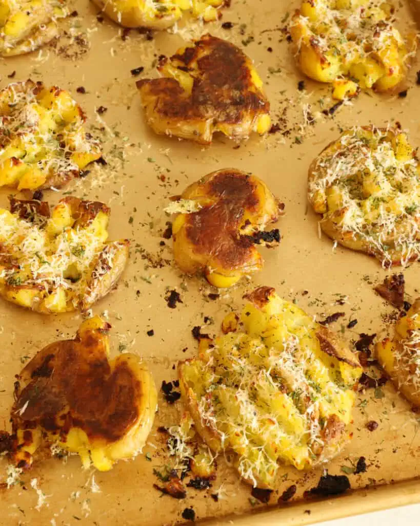Learn how to make perfectly crispy smashed potatoes with the added flavors of garlic, parmesan cheese, and fresh herbs.