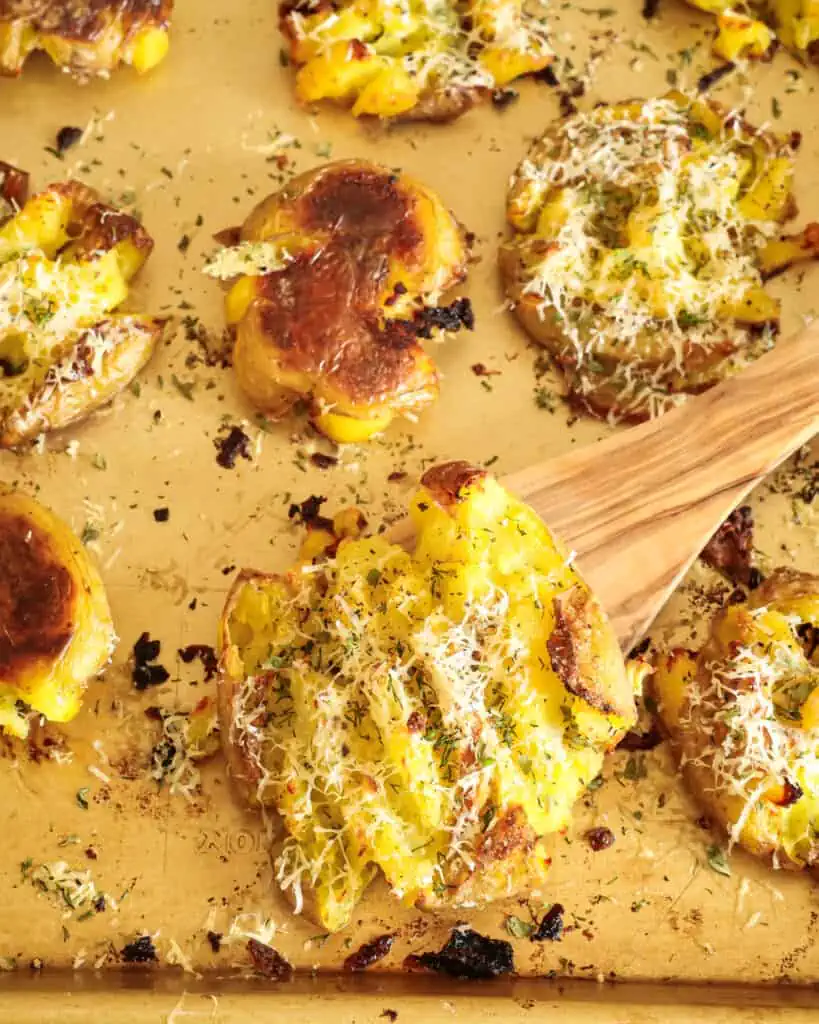 Learn how to make this perfectly crispy smashed potatoes recipe with the added flavors of garlic, parmesan cheese, and fresh herbs.