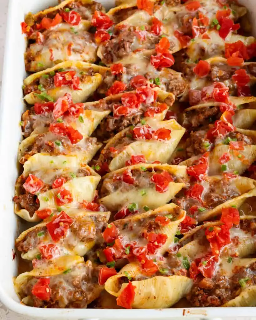 Taco stuffed pasta shells topped with diced tomatoes, green chilies, and minced jalapeno. 