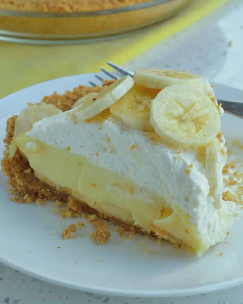 Banana pie topped with fresh whipped cream and banana slices. 