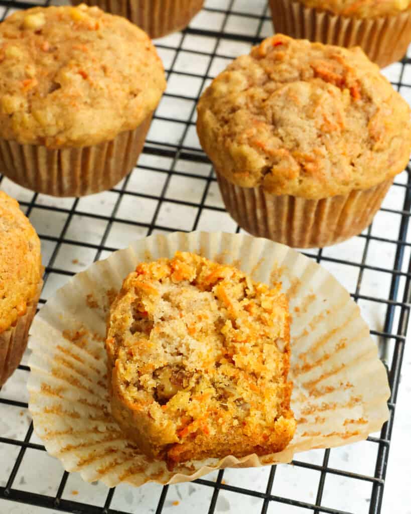 Sky high Bakery style Carrot Muffins dotted with shredded carrots, crushed pineapple, and walnuts spiced with ground cinnamon and ground ginger.
