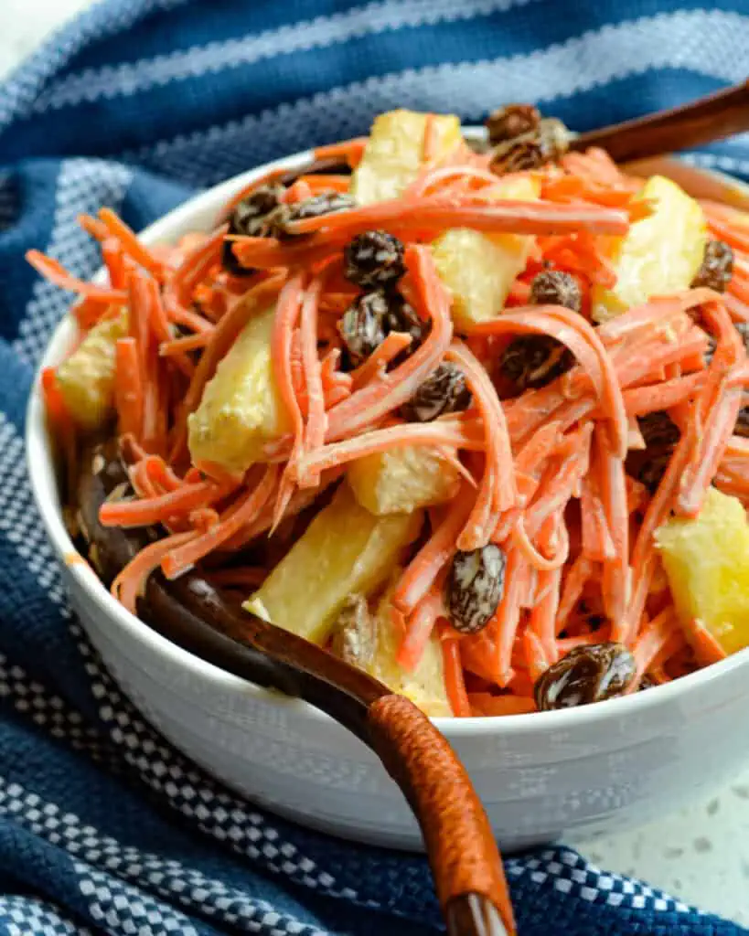This fresh and flavorful Carrot Salad is lightly sweetened with all-natural honey and freckled with plump raisins and crisp pineapple.  It goes with so many main courses, but it is particularly delicious with ribs and pork steaks. 