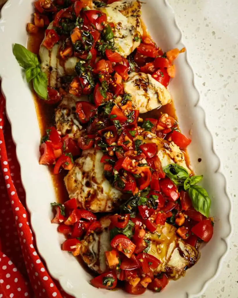 This Bruschetta Chicken combines Italian seasoned pan seared chicken topped with melted mozzarella and sun-ripened tomatoes, fresh garden basil, and sweet garlic all drizzled with a sweet flavorful balsamic glaze