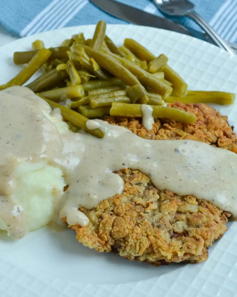 Country fried steak with mashed potatoes and green beans