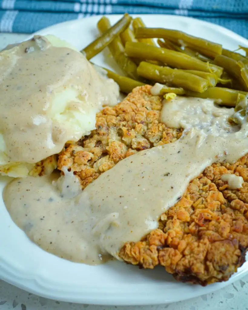 This Chicken-Fried Steak is a delectable Southern classic. Tender cube steak is double-breaded, fried to golden perfection, and smothered in a creamy flour and milk-based gravy made from the pan drippings.