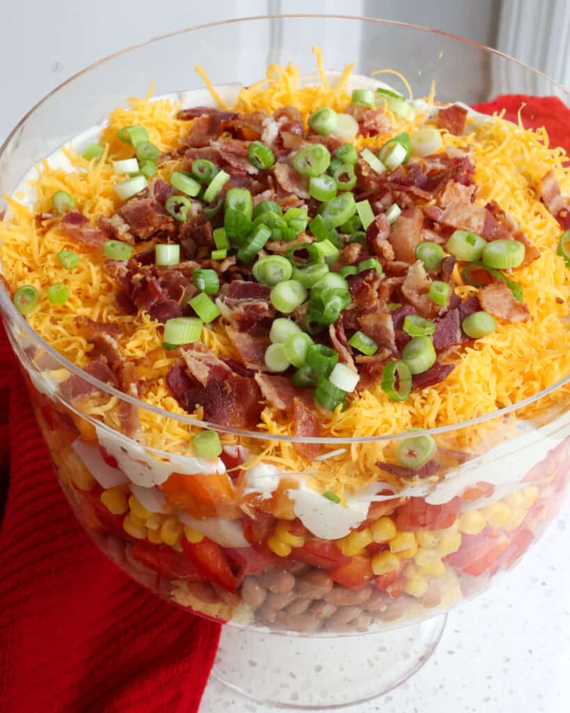 A trifle bowl layered with cornbread salad. 