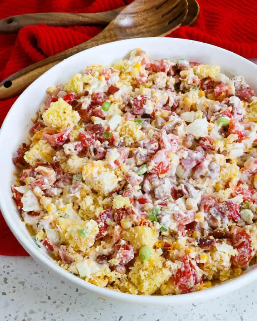 A serving bowl ful of cornbread salad. 