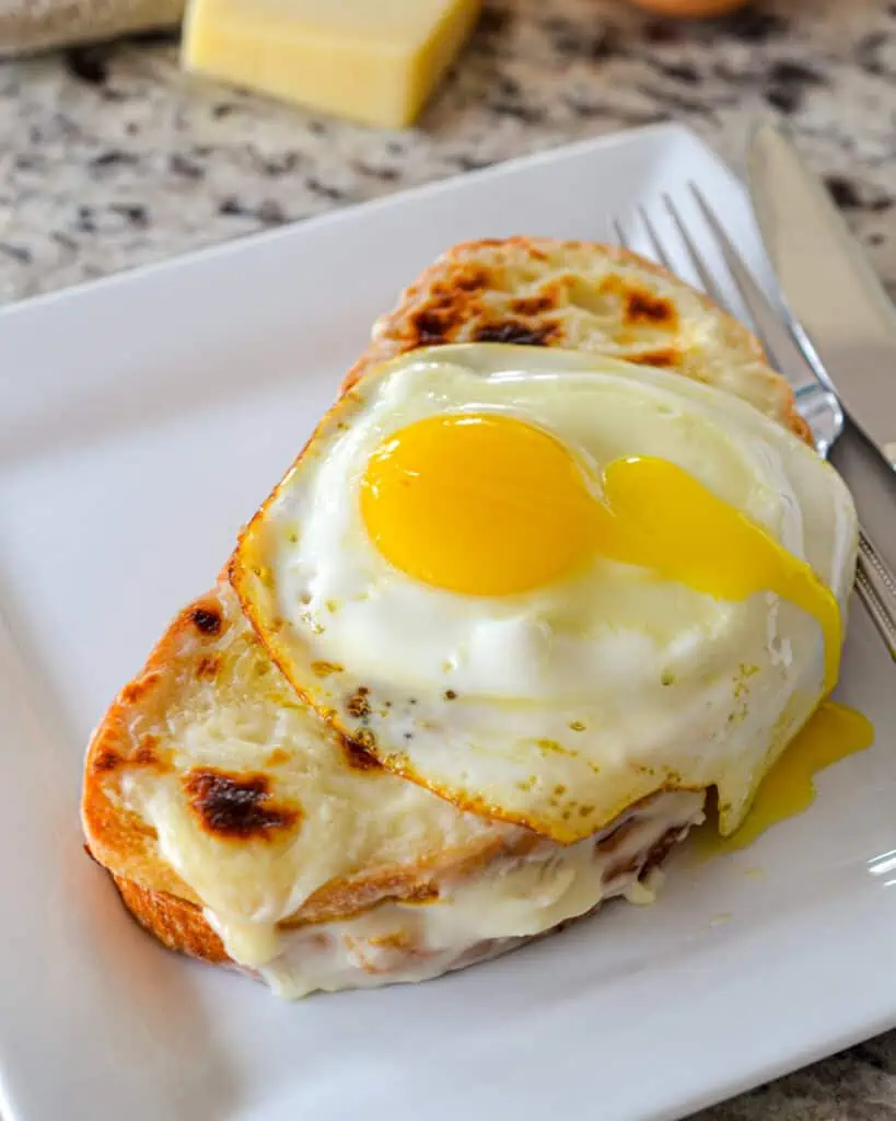 This classic Croque Madame is a highly sophisticated grilled cheese sandwich filled with ham, and creamy Mornay sauce and topped with a sunny-side-up egg. 