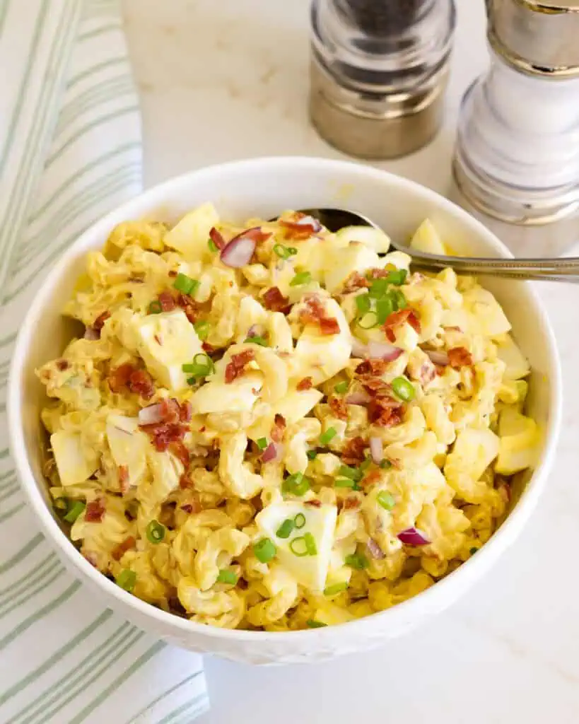 An overhead view of deviled egg pasta salad with bacon, celery, and onion. 