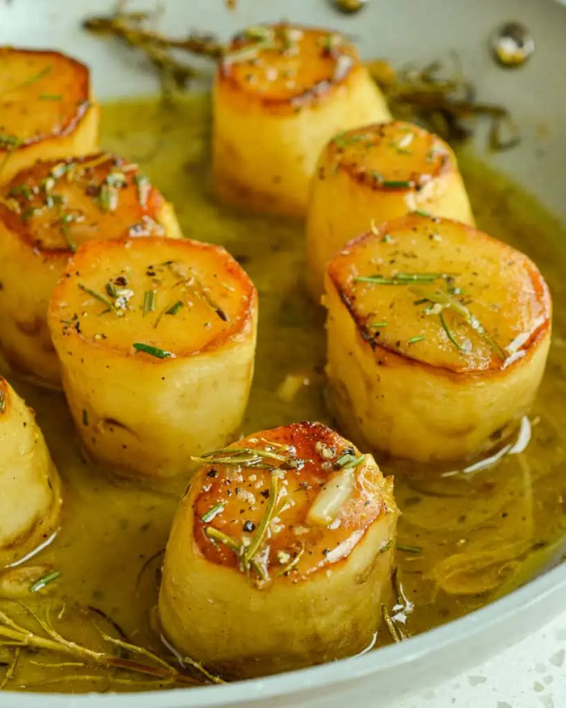 Elegant Fondant Potatoes are browned and then baked in creamy butter and rich chicken stock with aromatic fresh herbs. 