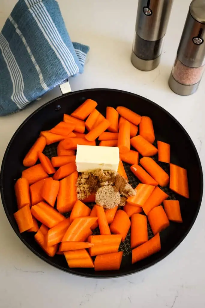 Add the carrots, butter, brown sugar, and water to a large skillet.
