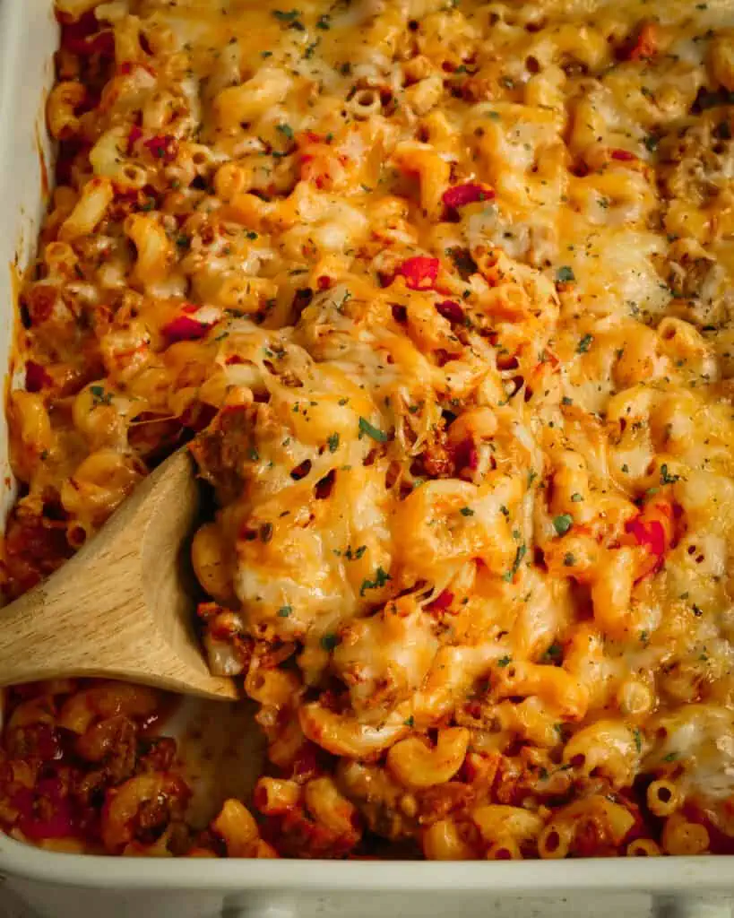 Hamburger Casserole with onions, bell peppers, garlic, tomatoes, elbow macaroni, and diced tomatoes, all under a blanket of melty Monterey Jack and cheddar cheese.