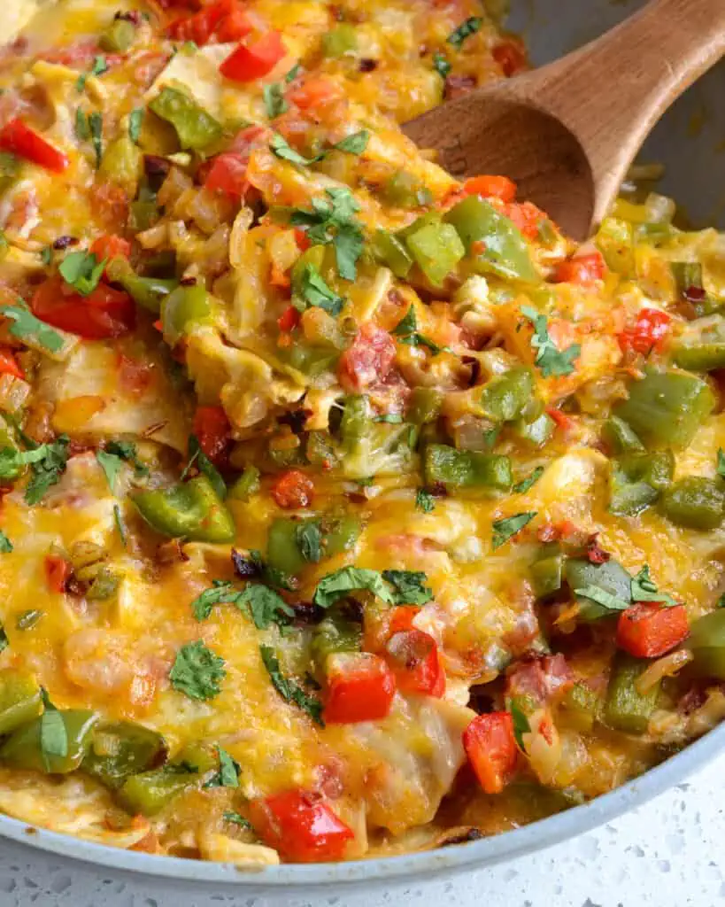 King Ranch Chicken is a fun family recipe full of layers of shredded chicken, corn tortillas, onions, bell peppers, garlic, jalapenos, and tomatoes in a creamy chicken sauce and topped with cheddar jack cheese. 