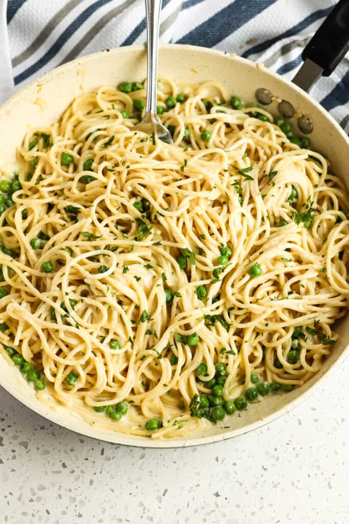 Mix the pasta noodles into the sauce with the peas and fresh chopped parsley.