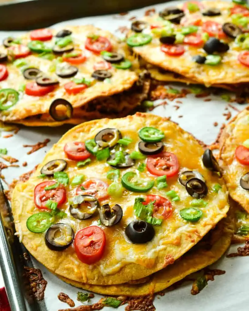 These Mexican pizzas are double decker crispy fried tortilla pizzas stuffed with seasoned beef, refried beans, and cheese. 