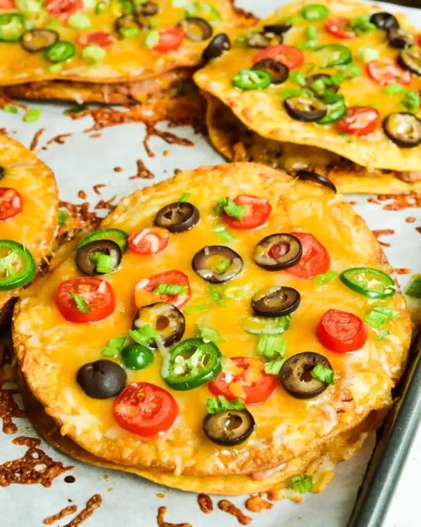 Family-friendly copycat Taco Bell Mexican Pizza is stuffed with refried beans and taco-seasoned ground beef, then topped with oodles of cheese, sun-ripened tomatoes, and spicy jalapenos.