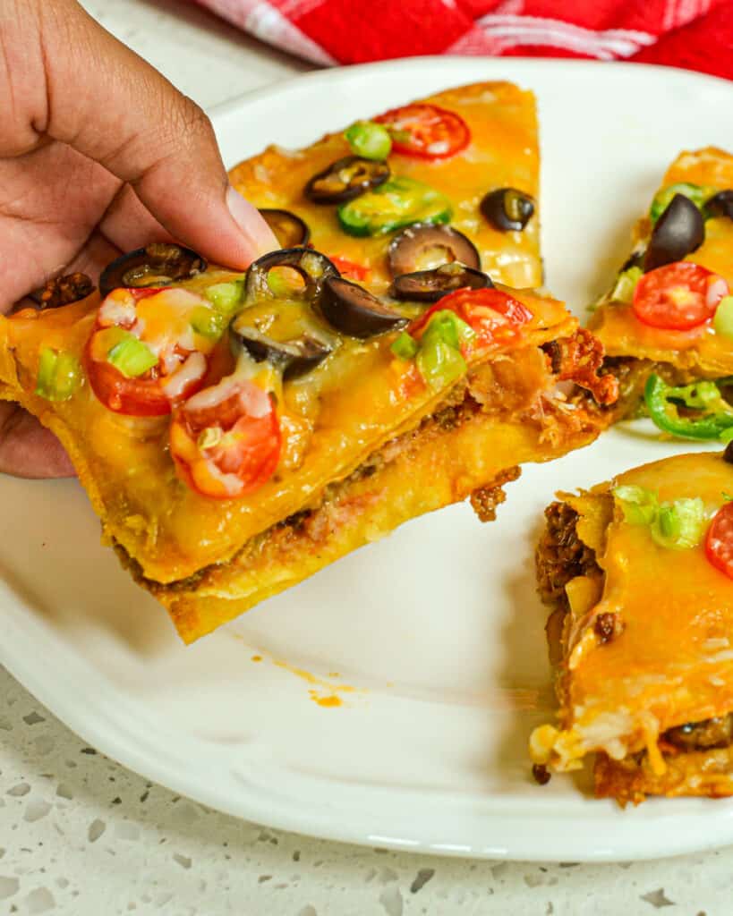 These delectable copycat Mexican pizzas are double-decker crispy fried corn tortilla pizzas stuffed with taco-seasoned beef, refried beans, cheddar, and Monterey Jack Cheese.  