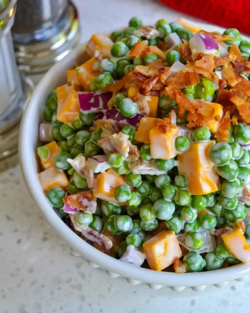 Looking for the perfect dish to bring to a potluck or picnic? This delicious pea salad recipe is sure to impress with its combination of fresh peas, bacon, and creamy dressing. 