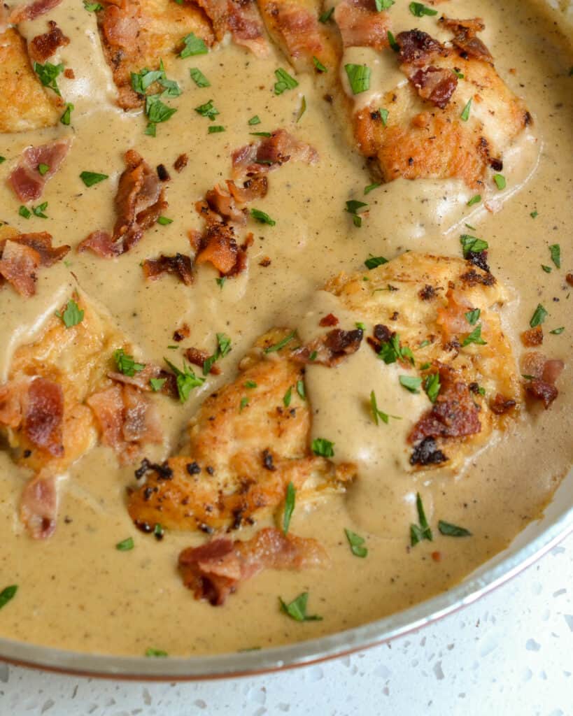 A large skillet ful of chicken smothered with a creamy gravy, crisp bacon and chopped fresh thyme. 