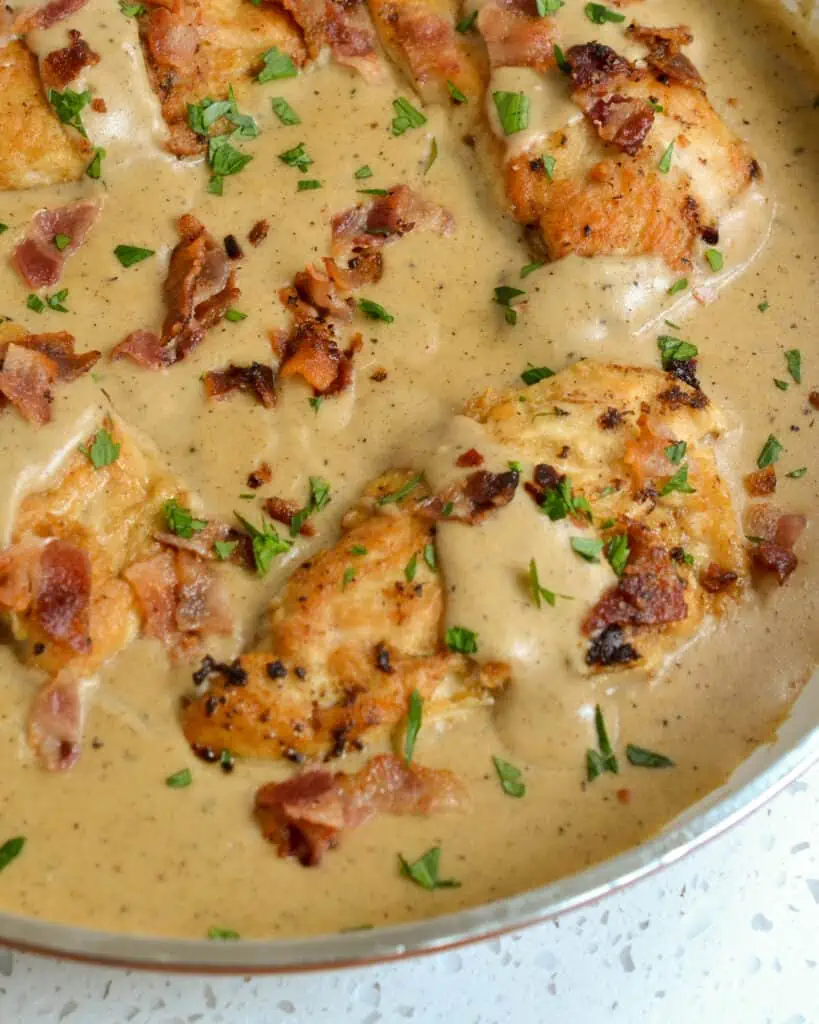 This easy one-skillet Smothered Chicken is comfort food at its best with crisp bacon and creamy seasoned gravy.  Enjoy it over mashed potatoes, with collard greens and creamed peas.