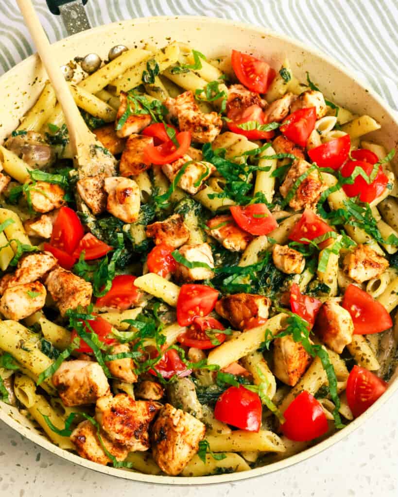 Add a little of the reserved pasta water to enhance flavor and help the sauce and pasta stick together. Top with chopped tomatoes and fresh basil ribbons.