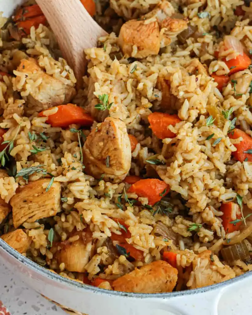 An easy Chicken and Rice Bake recipe with golden brown chicken,  onions, celery, carrots, and fluffy rice cooked up in one easy pot with the flavors of rosemary and thyme. This is one of our favorite one-pot meals for busy weeknights, and it is made without any canned soups. 