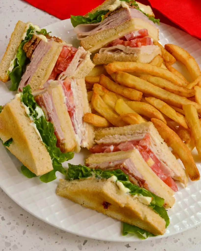 Learn how to make the ultimate club sandwich with bacon, turkey, ham, and cheddar, step by step. 