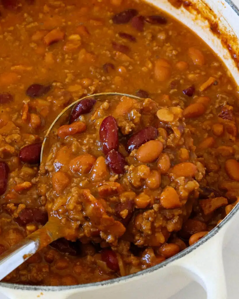 A Dutch oven full of cowboy beans. 