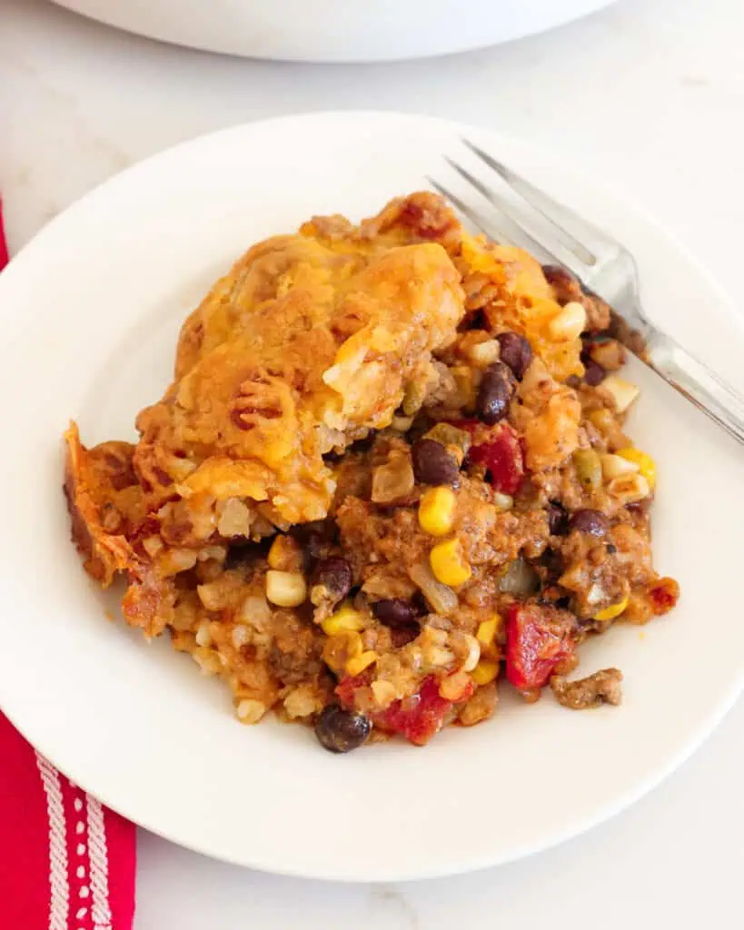 A fun and easy tater tot Cowboy Casserole with ground beef, onions, green beans, corn, tomatoes, and plenty of Cheddar and Monterey Jack Cheese. 