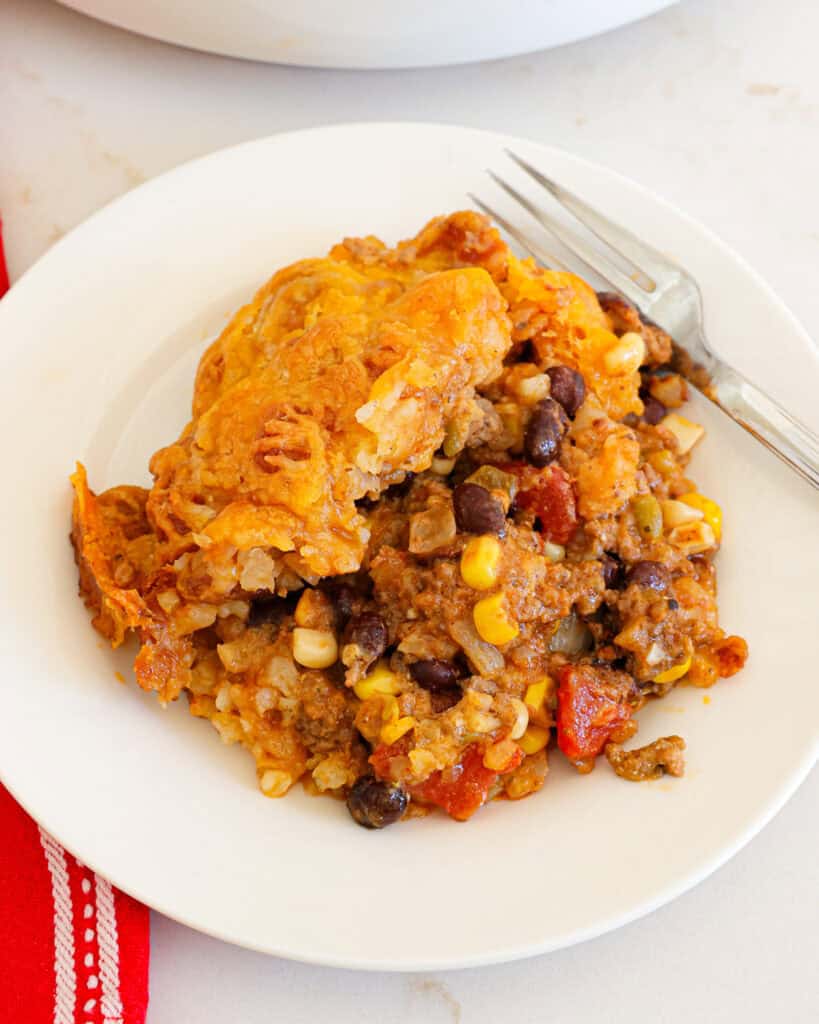 A single serving white plate full of cowboy casserole. 