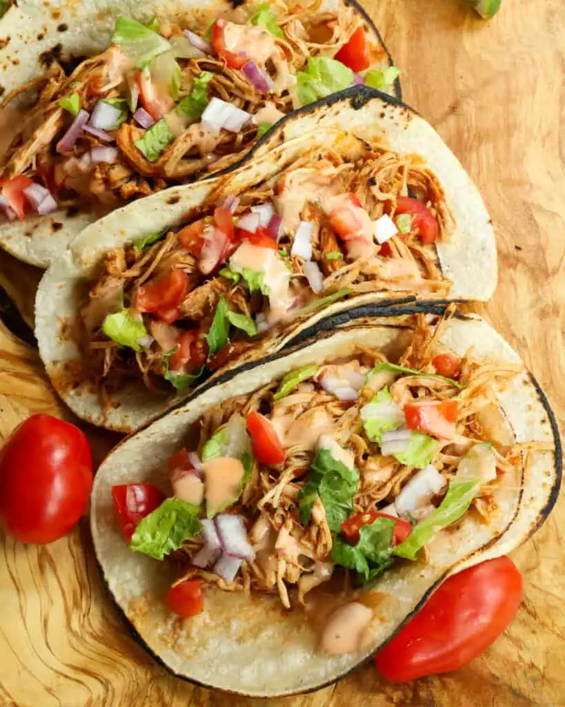 Spoon the tender chicken on to corn or flour tortillas.  Customize with all your favorite toppings and drizzle with chipotle ranch.