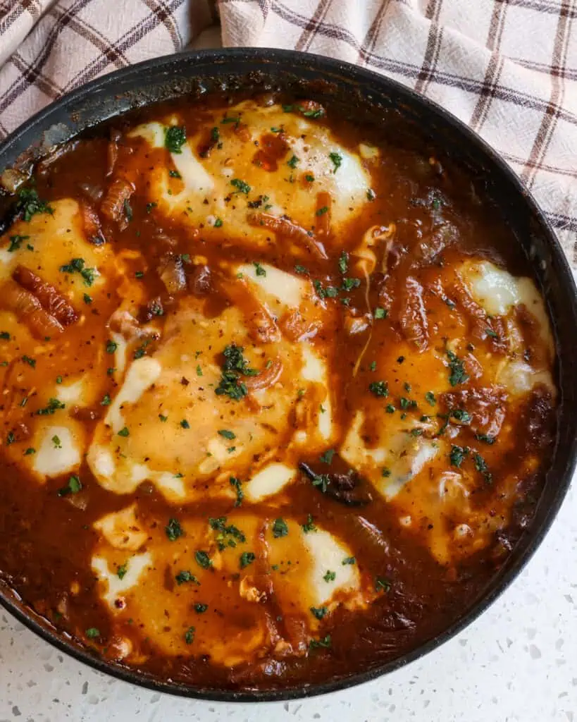 French Onion Chicken is chicken cutlets cooked golden brown and simmered in onion gravy and topped with fresh grated Parmesan Cheese and Swiss Cheese all melted to perfection. 