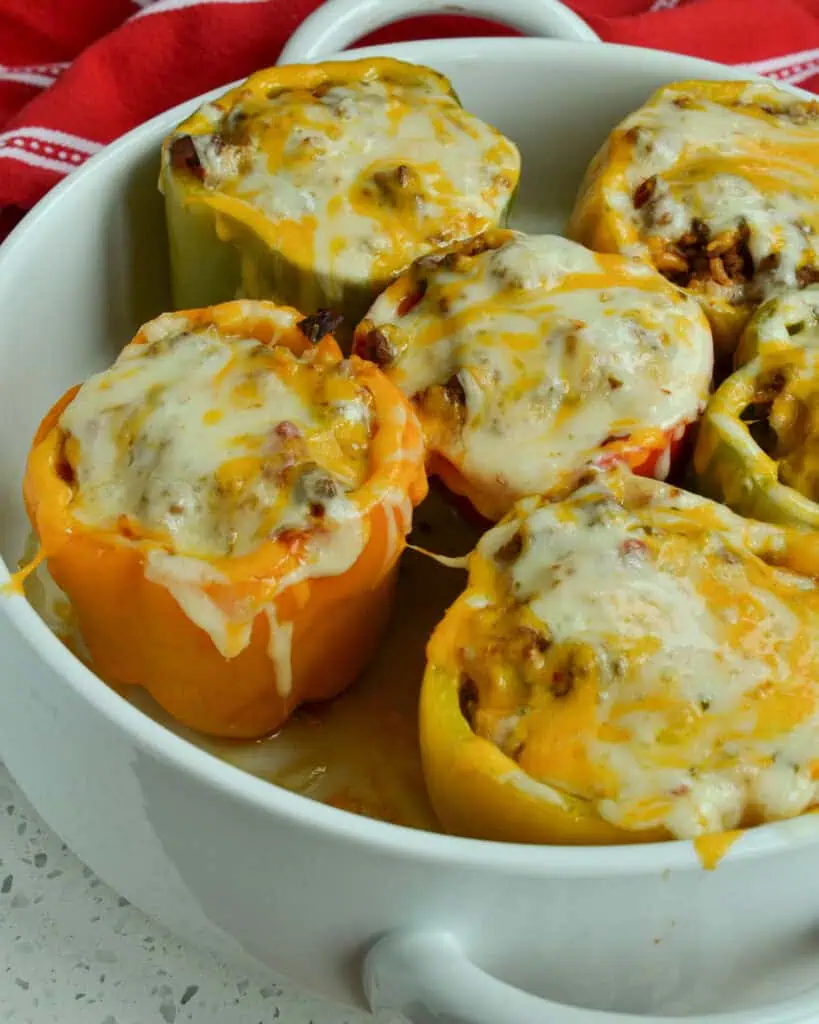 These festive, fun and easy Mexican Stuffed Peppers are loaded with hearty ground beef seasoned with the perfect mixture of spices, onions, tomatoes, rice and topped with sharp cheddar and zesty pepper jack cheese.