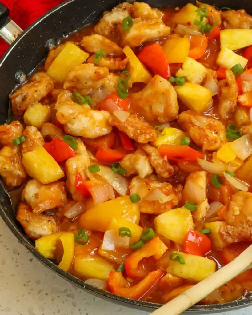 A quick and easy Pineapple Chicken Recipe with fresh pineapple, orange and red bell peppers, onions, and garlic all in a lightly sweetened pineapple sauce.