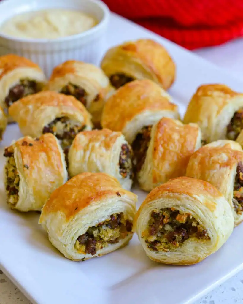 These sausage rolls combine buttery puff pasty stuffed with browned sausage, onion, a touch of Dijon mustard, and parsley.