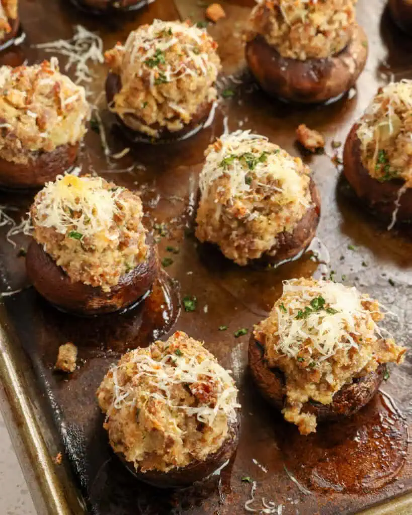 Sausage stuffed mushrooms on a baking sheet. 