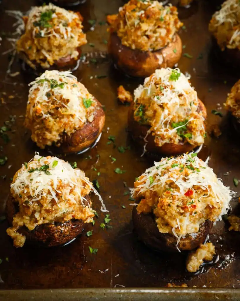 Sausage stuffed mushrooms on a baking sheet. 