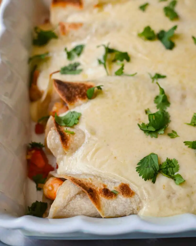Baked shrimp enchiladas in a casserole dish. 