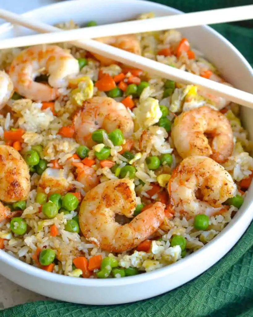 This easy Shrimp Fried Rice is lightly seasoned with ginger and garlic and full of carrots, peas, green onions, and fresh shrimp. Make this delicious, better-than-takeout fried rice at home for a simple and delicious dinner!