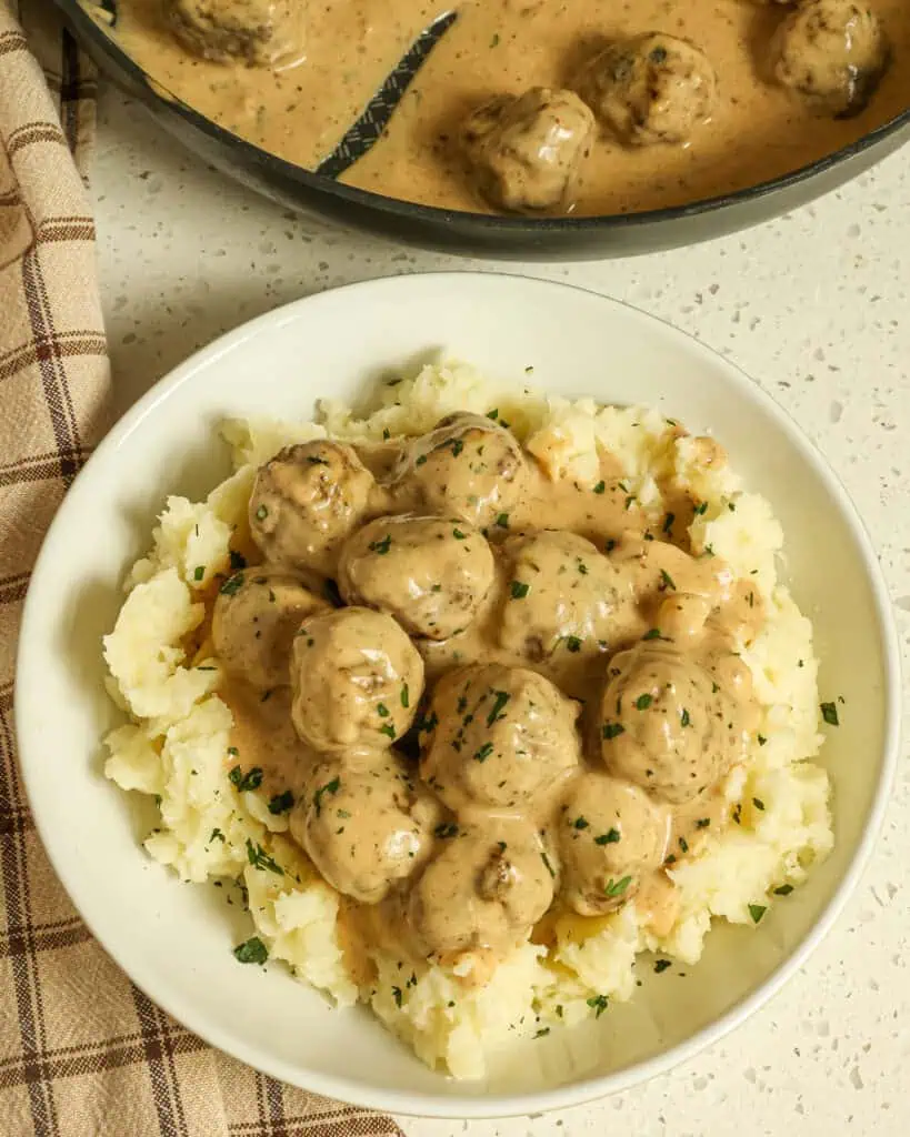 Tender Swedish Meatballs with hints of allspice and nutmeg are smothered in a rich and creamy gravy. These are a must-make and easy enough for a weeknight dinner. 